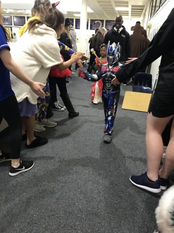 Lower schoolers walk through the Upper School and receive hundreds of high fives. 