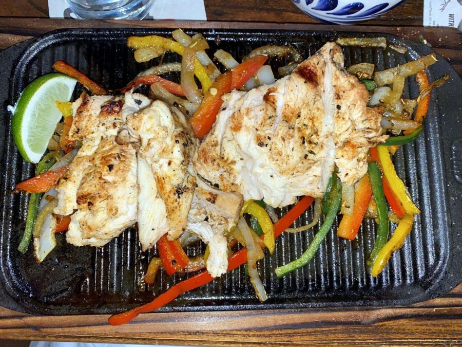 The chicken fajitas were served on top of colorful peppers and a sizzling skillet pan.