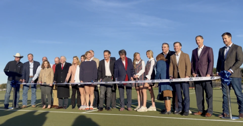 Several families who made this large undertaking happen, new turf fields and a new track, are pictured cutting the ribbon to officially open the new track.