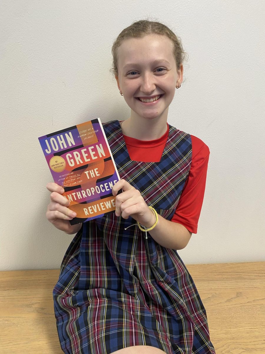 Evie Blan '27 holding "The Anthropocene Reviewed" by John Green.
